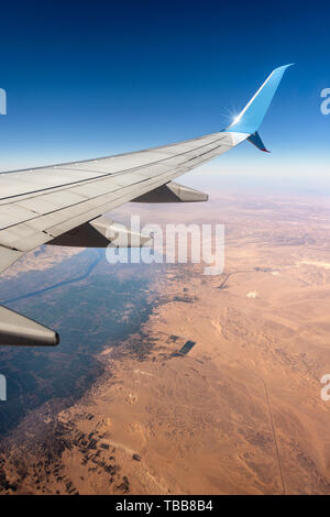 Luftbild der Sahara und den Nil mit der Hijazah Stadt in der Nähe von Luxor und einem Flugzeugflügel. Ägypten, Afrika. Stockfoto