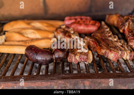 "Argentinischen Grill' Grill auf live Coal (keine Flamme), Rindfleisch "Asado", Brot, "Chorizo" und Blutwurst bin orcilla' Stockfoto