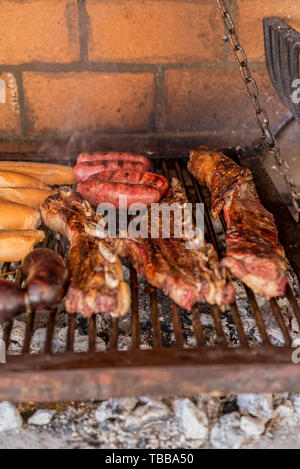 "Argentinischen Grill' Grill auf live Coal (keine Flamme), Rindfleisch "Asado", Brot, "Chorizo" und Blutwurst bin orcilla' Stockfoto