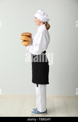 Schöne weibliche Bäcker in der Nähe von hellen Wand Stockfoto