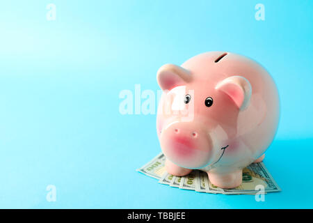 Happy Sparschwein mit Dollar auf farbigen Hintergrund, Platz für Text. Finanzen, Geld sparen Stockfoto