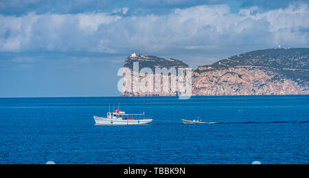 Blick von Capo Caccia bei Alghero (L'Alguer), als Fischerboot entere den Hafen, Sardinien, Italien. Stockfoto