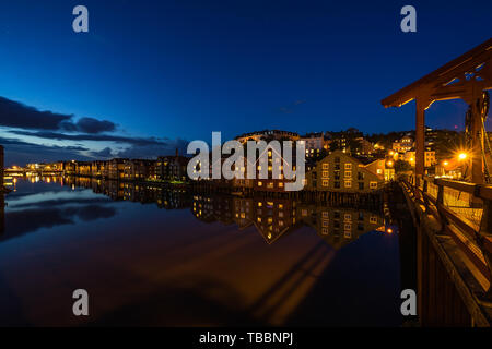 Typischen alten Holzhäusern auf Nidelva Fluss gesehen von Old Town Bridge (Gamle Bybro) in der Dämmerung. Trondheim, Norwegen, August 2018 Stockfoto