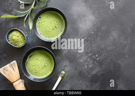 Stillleben mit japanischen Matcha grüner Tee in der Schüssel mit Zubehör auf Schwarz. Blick von oben. Platz für Text. Stockfoto