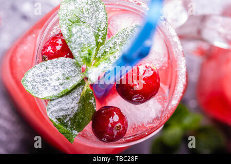 Iced hausgemachte Limonade mit Preiselbeeren, Zitrusfrüchte und frischer Minze Blatt in einem Cocktail Glas mit Strohhalm Stockfoto