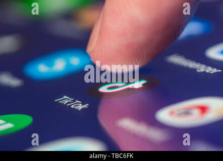 Finger drücken TikTok App Symbol (AKA Douyin) auf einem Touchscreen auf einem Tablet-PC oder Handy Gerät. Laden Tik Tok Anwendung. TikTok Verknüpfung. Stockfoto