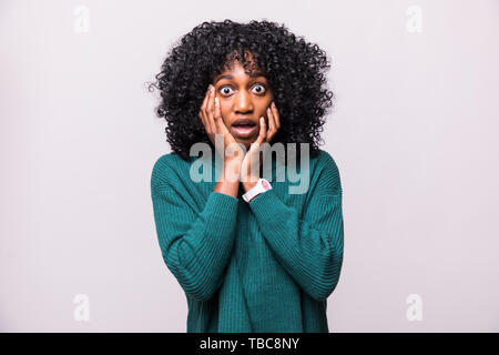 Portrait von Angst junge afrikanische frau frau mit Curly Frisur schockiert auf weißem Hintergrund Stockfoto