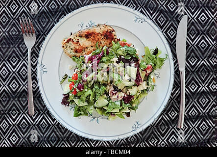 Draufsicht auf Platte mit frischem Salat und Gemüse, Hähnchen Filet und Geschirr Stockfoto