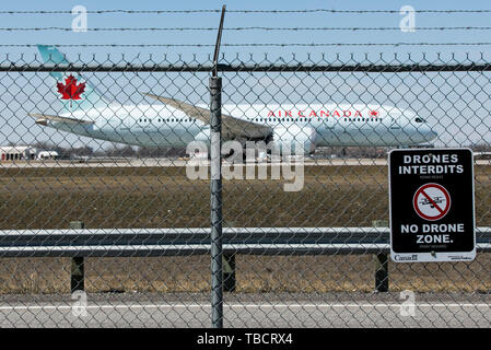 Ein Air Canada Boeing 787-8 Dreamliner Flugzeug gesehen, die hinter einem "Kein Drone Zone" warnzeichen an Montréal-Pierre Elliott Trudeau International Stockfoto