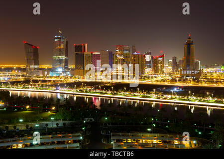 Luftaufnahme von beleuchteten Gebäuden und Straßen von Doha, Katar während der Nacht. Lange Belichtung. Stockfoto