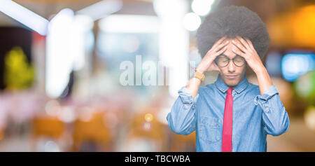 Junge afrikanische amerikanische Geschäftsmann mit afro Haar zu tragen Brillen und rote Krawatte Kopfschmerzen leiden, verzweifelte und betonte, weil Schmerz und Migräne Stockfoto