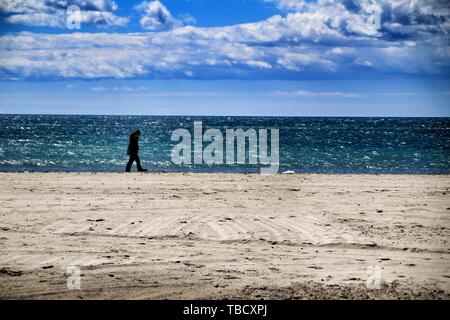 Santa Pola, Alicante, Spanien - Mai 2, 2019: Junge Frauen wandern durch das Ufer mit dem Hund in einen sonnigen Tag des Frühlings in Santa Pola, Alicante. Stockfoto