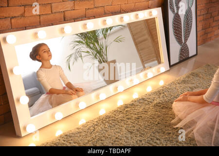 Süße kleine Ballerina vor dem Spiegel zu Hause sitzen Stockfoto