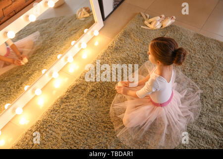 Süße kleine Ballerina vor dem Spiegel zu Hause sitzen Stockfoto