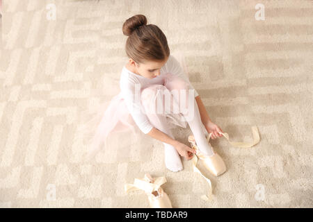 Süße kleine Ballerina in Spitzenschuhen zu Hause Stockfoto