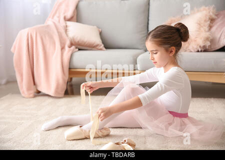 Süße kleine Ballerina in Spitzenschuhen zu Hause Stockfoto