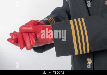 Vier goldene Streifen auf eine einheitliche Jacke mit Händen tragen rote Handschuhe. Stockfoto