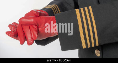 Vier goldene Streifen auf eine einheitliche Jacke mit Händen tragen rote Handschuhe. Stockfoto