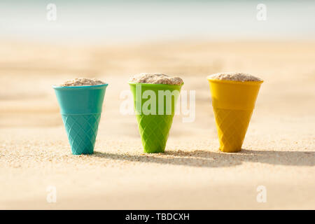 Bunte Kegel gefüllt mit Sand Graben am Strand Stockfoto