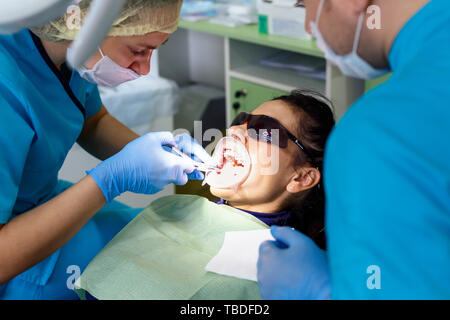 Zahnarzt Zähne behandeln zu Frau Patienten in der Klinik. Weiblichen professionellen Arzt stomatologist bei der Arbeit. Zahnärztliche Geräte für den Hintergrund. Zahnmedizinische Check-up. Stockfoto