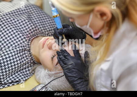 Microblading Augenbrauen Arbeitsablauf in einem Schönheitssalon. Frau mit ihren Augenbrauen getönt. Semi-Permanent Make-up für Augenbrauen. Konzentrieren Sie sich auf das Modell von Gesicht und ey Stockfoto