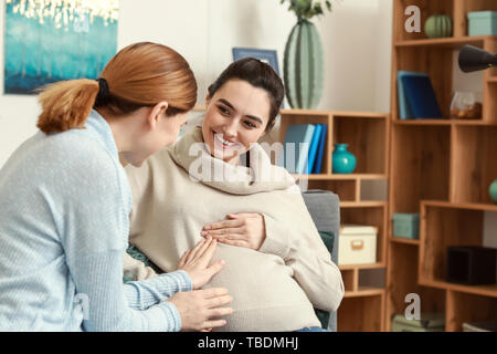 Doula mit schwangeren Frau zu Hause Stockfoto