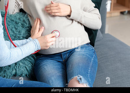 Doula mit schwangeren Frau zu Hause Stockfoto