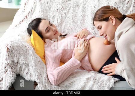 Monitrice Pflege für schwangere Frau zu Hause Stockfoto