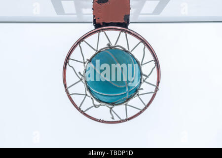 Ein Basketball geht durch das Netz auf eine Nachbarschaft Spielplatz Stockfoto