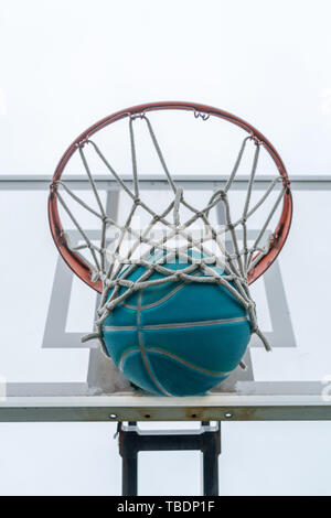 Ein Basketball geht durch das Netz auf eine Nachbarschaft Spielplatz Stockfoto