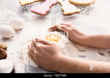Frau, die Teig für Ostern Cookies bei Tisch Stockfoto