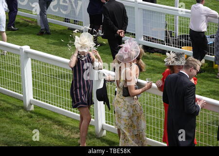 Epsom Downs, Surrey, Großbritannien. 1. Juni 2019. Epsom Downs, Surrey, UK Die Damen halten Sie Ihre Hüte wie der Wind am Derby Tag erhält an der Investec Derby Festival Stockfoto