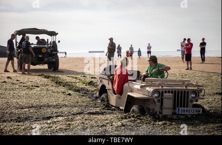 Frankreich. 01. Juni 2019, France (Frankreich), Arromanches-Les-Bains: ein Jeep fuhr in den Schlamm an Gold Strand zwischen den Resten der ehemaligen Hafen. Nach der Landung der alliierten Truppen im Zweiten Weltkrieg, einer der zwei künstliche Häfen (Mulberry B) gebaut wurde an der Küste von Arromanches-les-Bains, durch die Truppen und liefert an Land gebracht wurden. 06.06.2019 ist der 75. Jahrestag der Landung der alliierten Truppen in der Normandie (D-Day). Foto: Kay Nietfeld/dpa Stockfoto