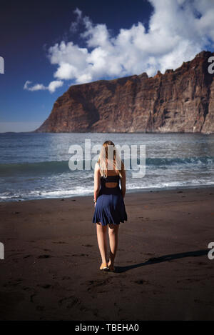 Junge Frau zu Fuß am Strand von Los Gigantes auf Teneriffa, Kanarische Inseln, Spanien Stockfoto