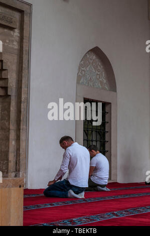 Sarajevo, Bosnien: muslimische Männer beten in Richtung Mekka außerhalb der Gazi-husrev-Beg Moschee (1532) in der Altstadt Bascarsija Nachbarschaft Stockfoto