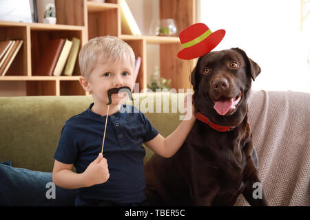 Süßer kleiner Junge spielt mit lustigen Hund zu Hause Stockfoto