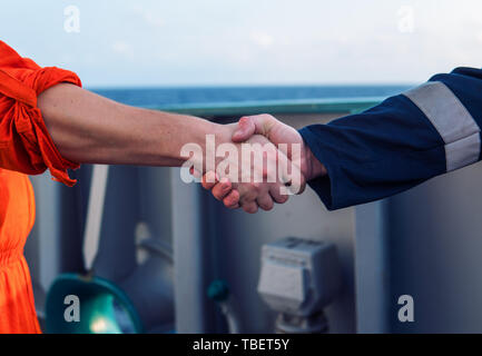 Marine Auftragnehmer Geschäftsmann handshaking Mit arbeiter auf dem Schiff. Stockfoto