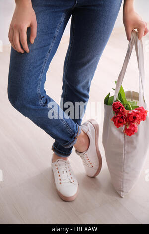 Frau mit eco Beutel mit Blumen im Innenbereich Stockfoto
