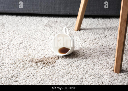 Tasse Kaffee auf dem Teppich verschüttet Stockfoto