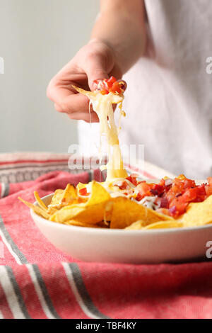 Frau essen lecker Nachos mit Käse, Nahaufnahme Stockfoto