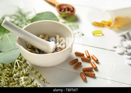 Mörtel mit trockenen Blumen, Kräuter und pflanzliche Pillen auf Tabelle Stockfoto