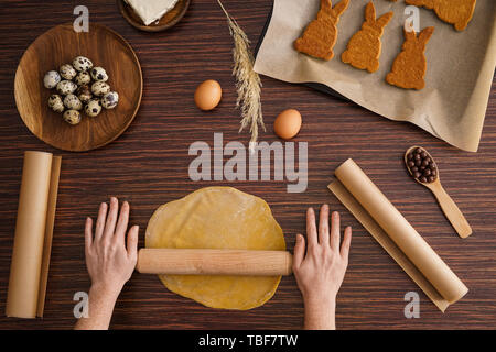 Frau kochen lecker Ostern Cookies auf hölzernen Tisch Stockfoto