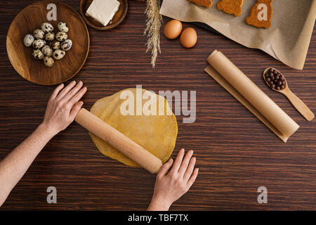 Frau kochen lecker Ostern Cookies auf hölzernen Tisch Stockfoto