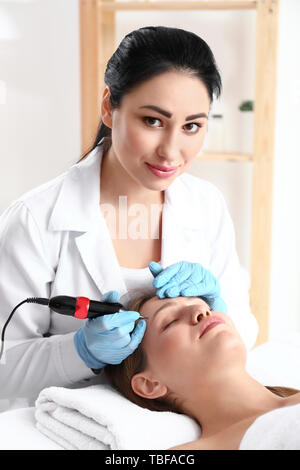 Junge Frau, die sich Verfahren der Permanent Make-up in Beauty Salon Stockfoto