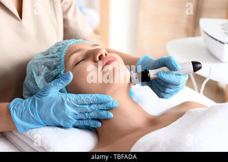 Junge Frau, die sich Verfahren der rf Anheben im Beauty Salon Stockfoto