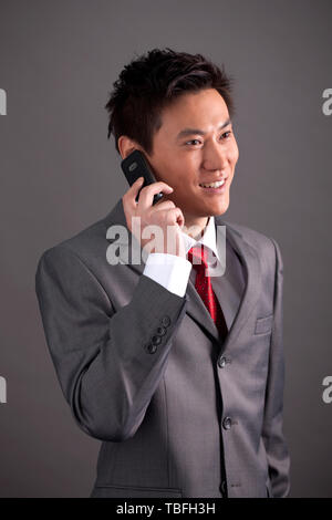 Ein männlicher Angestellter verwendet ein Mobiltelefon. Stockfoto