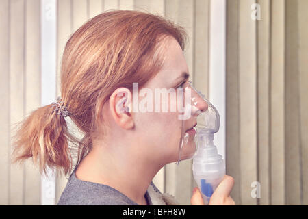 Frau tut, die Inhalation mit vernebler Maske, denn sie hat die interstitielle Krankheit. Stockfoto