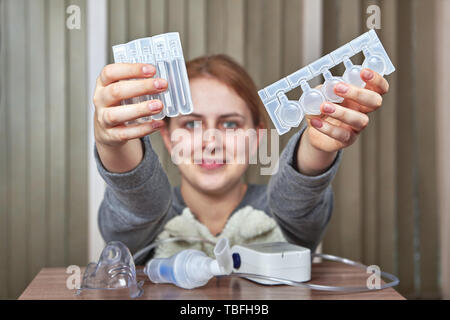 Mädchen mit Zerstäuber für die Behandlung von Atemwegserkrankungen bereitet Arzneimittel zur Inhalation. Stockfoto