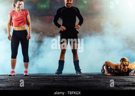 Junge hart arbeitende Menschen Züge Push-ups bei crossfit Fitnesscenter Stockfoto