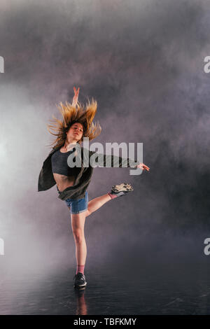 Tänzerin zeigt ihre Eleganz, indem sie ihr Bein hoch über den Kopf. Stockfoto